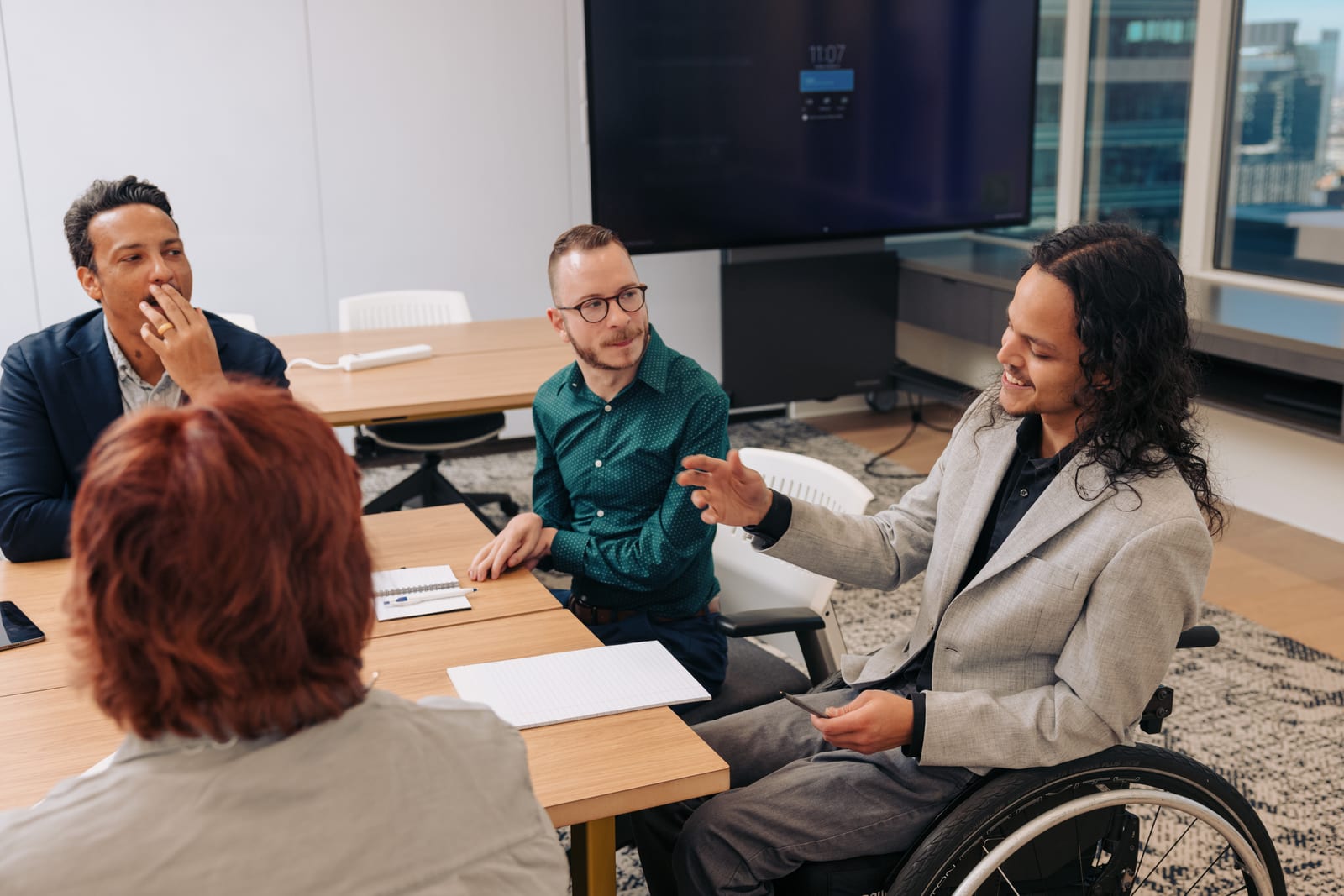 Jonathan speaking confidently in a meeting, representing inclusive leadership.